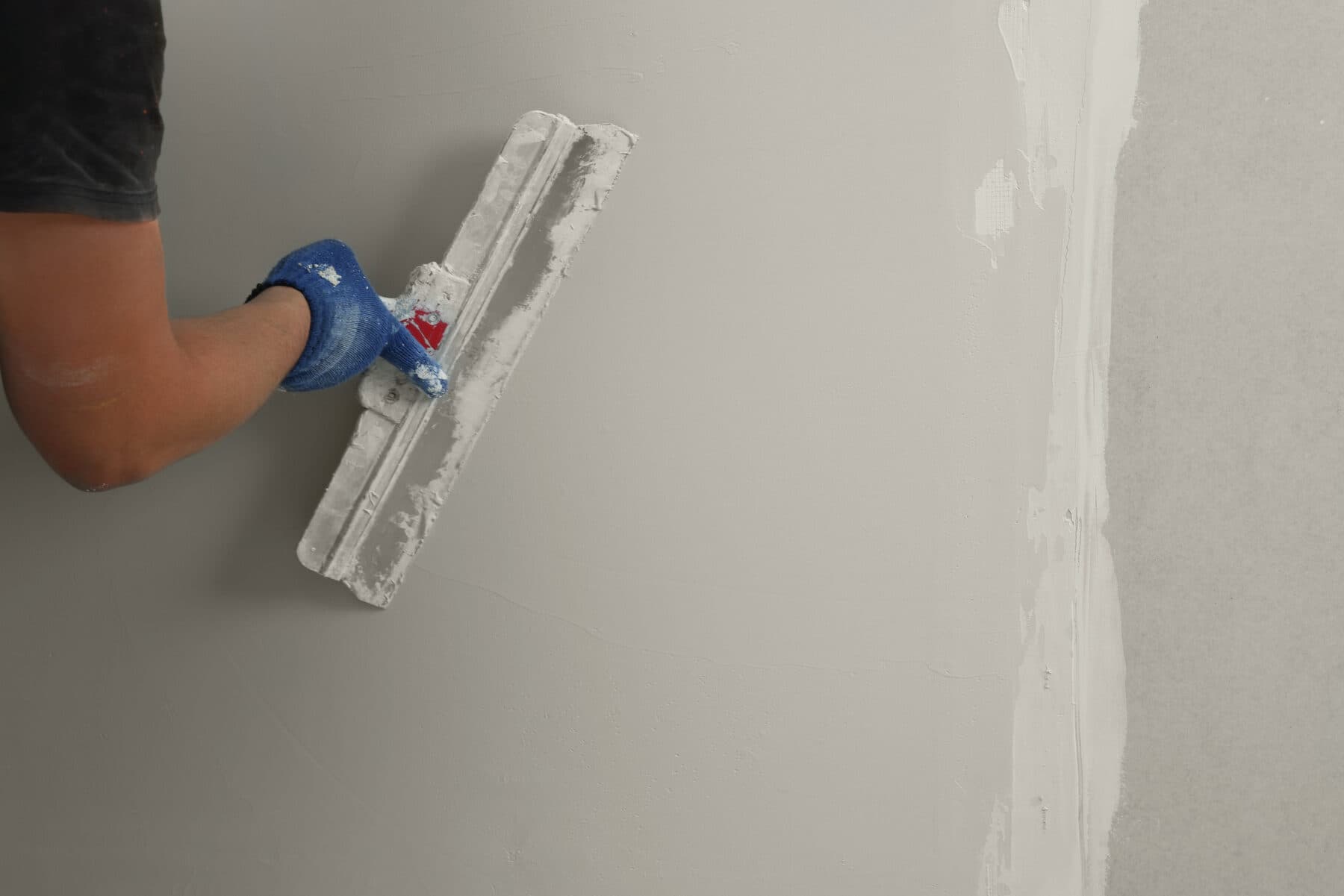 Close-up of a Graceful Interiors finisher working a corner bead